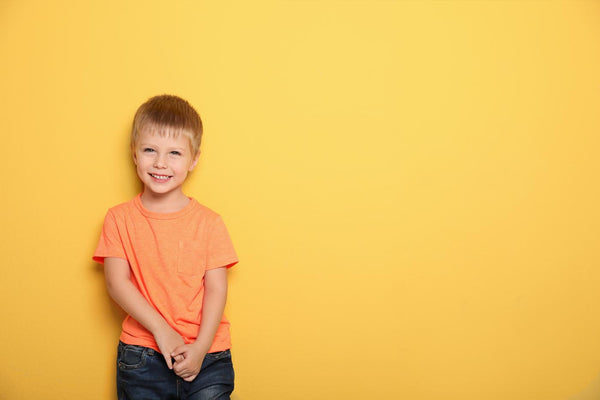 Bright clothes for boys; boy in orange t-shirt and yellow background by Gen Woo 