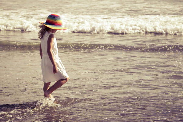 Girl in sundress walking along the beach
