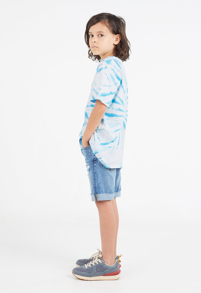 Side view as the young boy wears the Boys Blue and White Tie-Dye T-Shirt by Gen Woo 