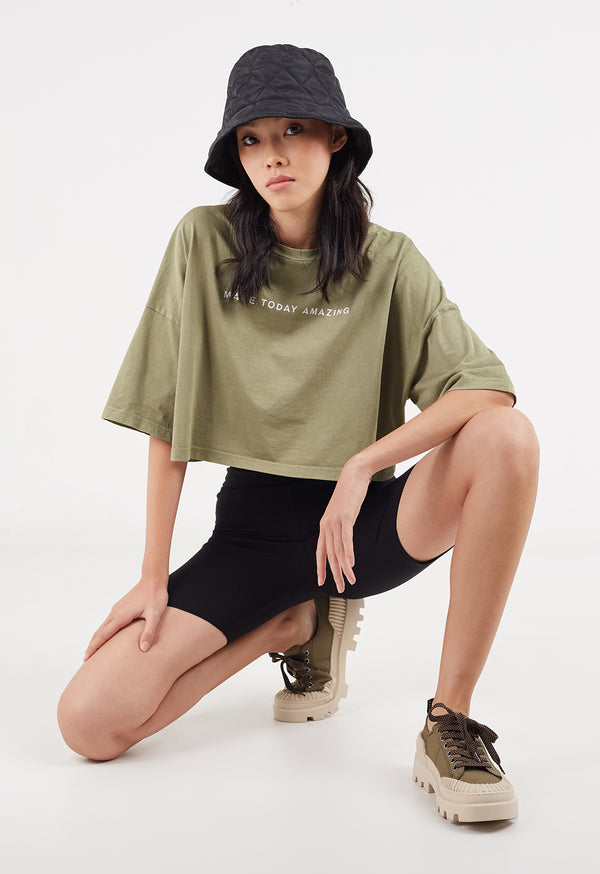 The model wears the Ladies Cropped Slogan T-Shirt by Gen Woo