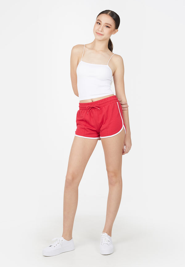 The model poses in the Red and White Retro Ladies Track Shorts by Gen Woo