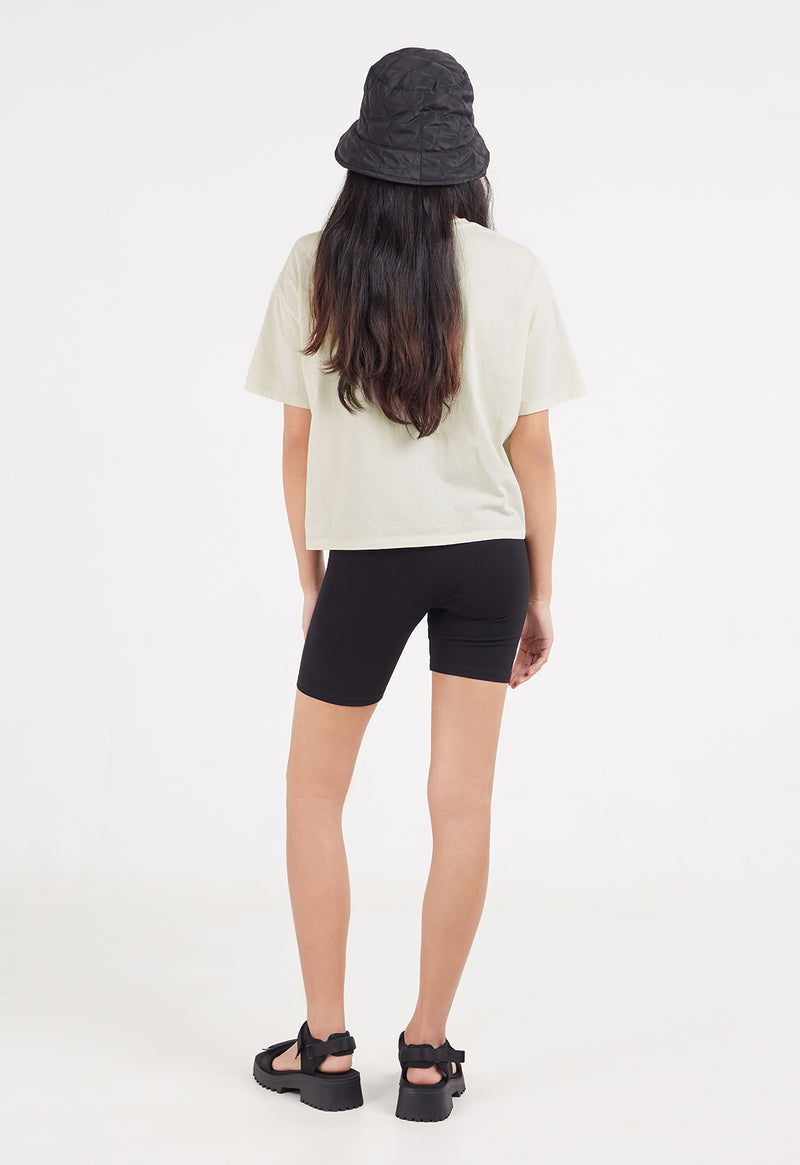 Back view as the model wears the Ladies Boxy Cropped Slogan T-Shirt by Gen Woo