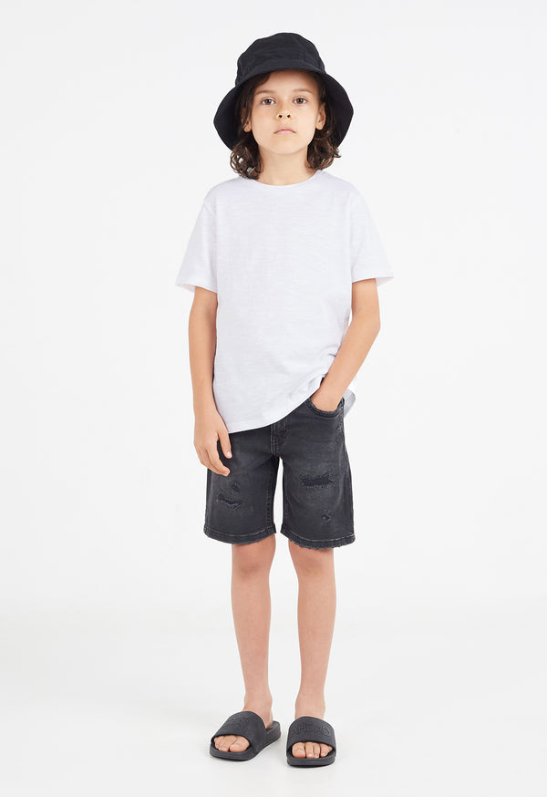 The young boy wears the Boys Classic Crew Neck White T-Shirt by Gen Woo with a bucket hat, shorts and sliders