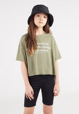 The young girl wears the Girls Basic Black Cycling Shorts by Gen Woo with a slogan tee and bucket hat