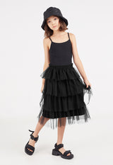 The young girl models the Black Tulle Girls Midi Skirt by Gen Woo