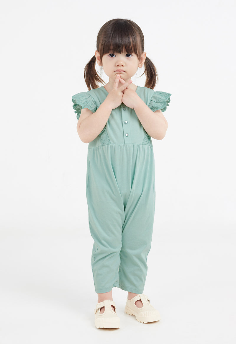 The young girl wears the Mint Broderie Trim Long Leg Romper by Gen Woo