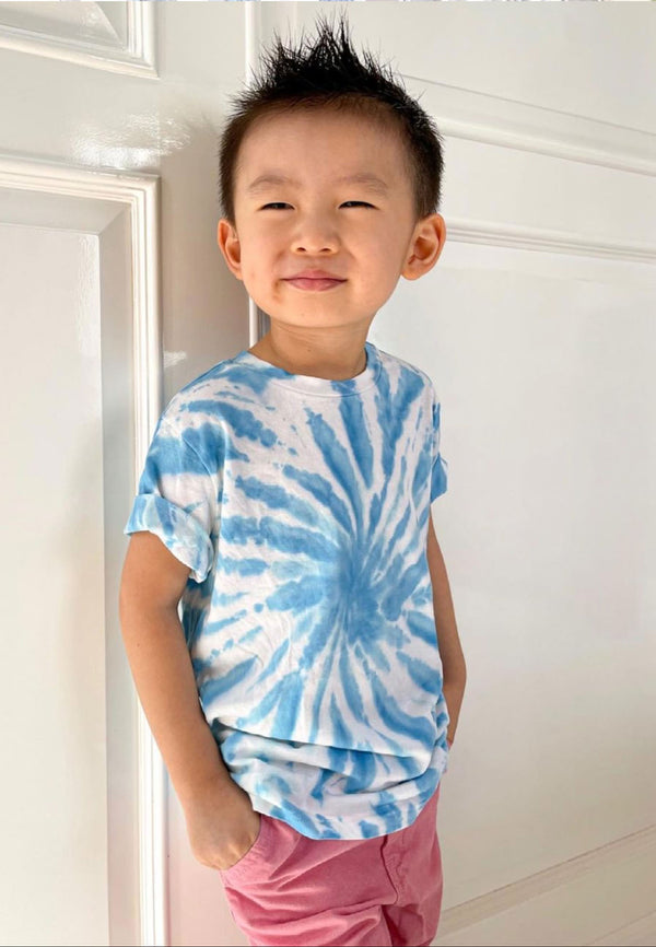 The young boy wears the Boys Blue and White Tie-Dye T-Shirt by Gen Woo with pink shorts