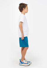 Side view of model wearing Blue Boys Bermuda Sweat Shorts by Gen Woo.