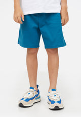 (Close up) Model wears Blue Boys Bermuda Sweat Shorts by Gen Woo. 