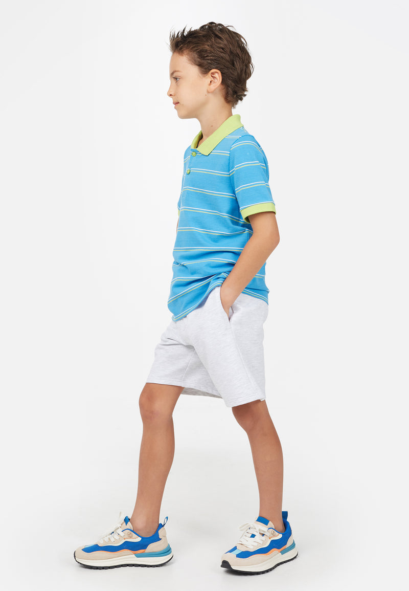 Side view of model wearing Blue Striped Boys Polo T-Shirt by Gen Woo. 