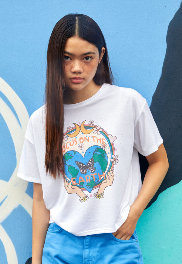 The teen girl wears the “Focus on the Earth” Cropped Graphic Tee by Gen Woo