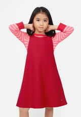 Young girl wears the Raspberry Red Twill Pinafore Dress by Gen Woo