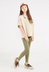 The teen girl wears the Khaki Washed Effect Girls Cotton-Rich Leggings by Gen Woo with trainers and a tee