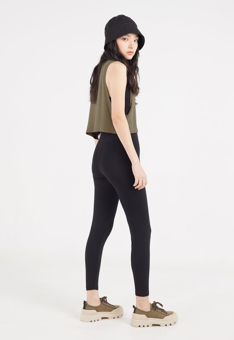 Ladies Vest by Gen Woo. Our coriander coloured vest is cropped length to mid waist. The vest has drapey and loose fit. Styled as a layering top for a sporty look. –Sidet view