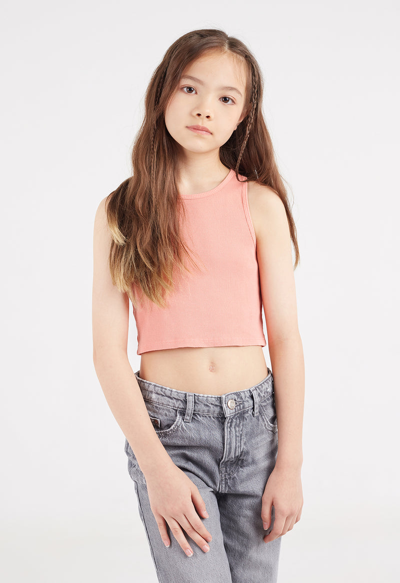 Close-up as the young girl models the Salmon Cropped Girls Tank Top by Gen Woo