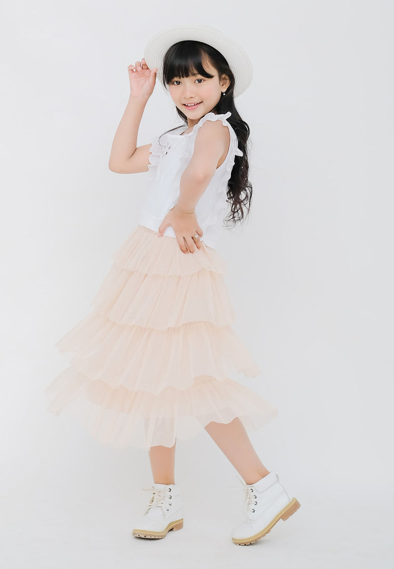 The young girl wears the Nude Tulle Girls Midi Skirt by Gen Woo