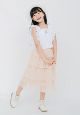 The young girl wears the Nude Tulle Girls Midi Skirt by Gen Woo with a white tee and sunhat