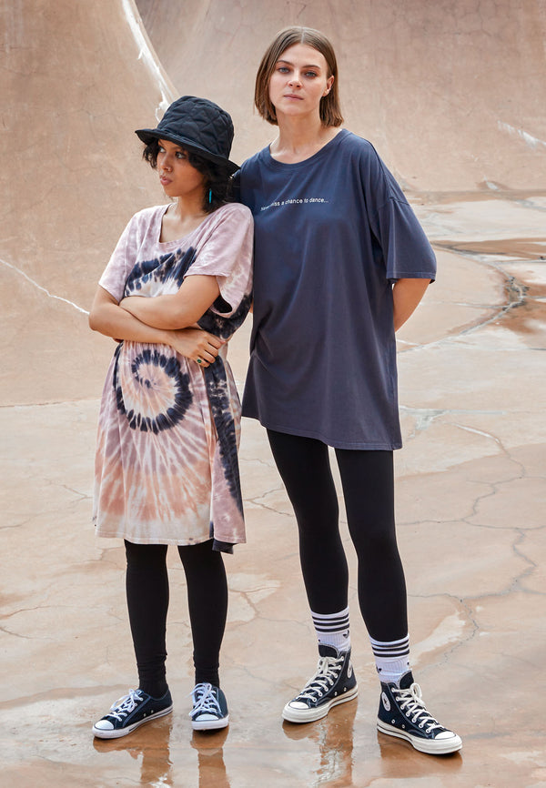 The model on the left wears the Ladies Oversized Tie Dye Tunic Top by Gen Woo with leggings and a bucket hat