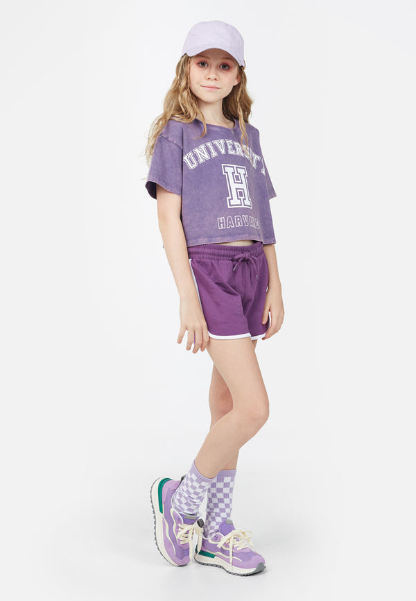 Model wears Teen Violet Varsity Crop T-Shirt by Gen Woo. 