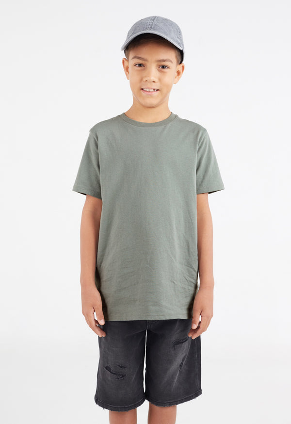 The young boy wears the Boys Classic Crew Neck Sage Green T-Shirt by Gen Woo with a baseball cap