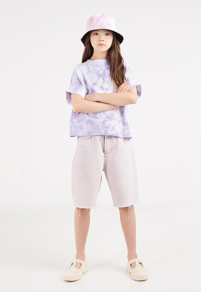 The teen girl poses wearing the Purple and White Girls Tie-Dye T-Shirt by Gen Woo