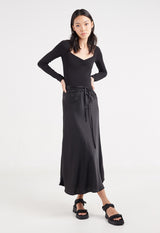 Model wears Ladies Black Long-Sleeved Bodysuit by Gen Woo.