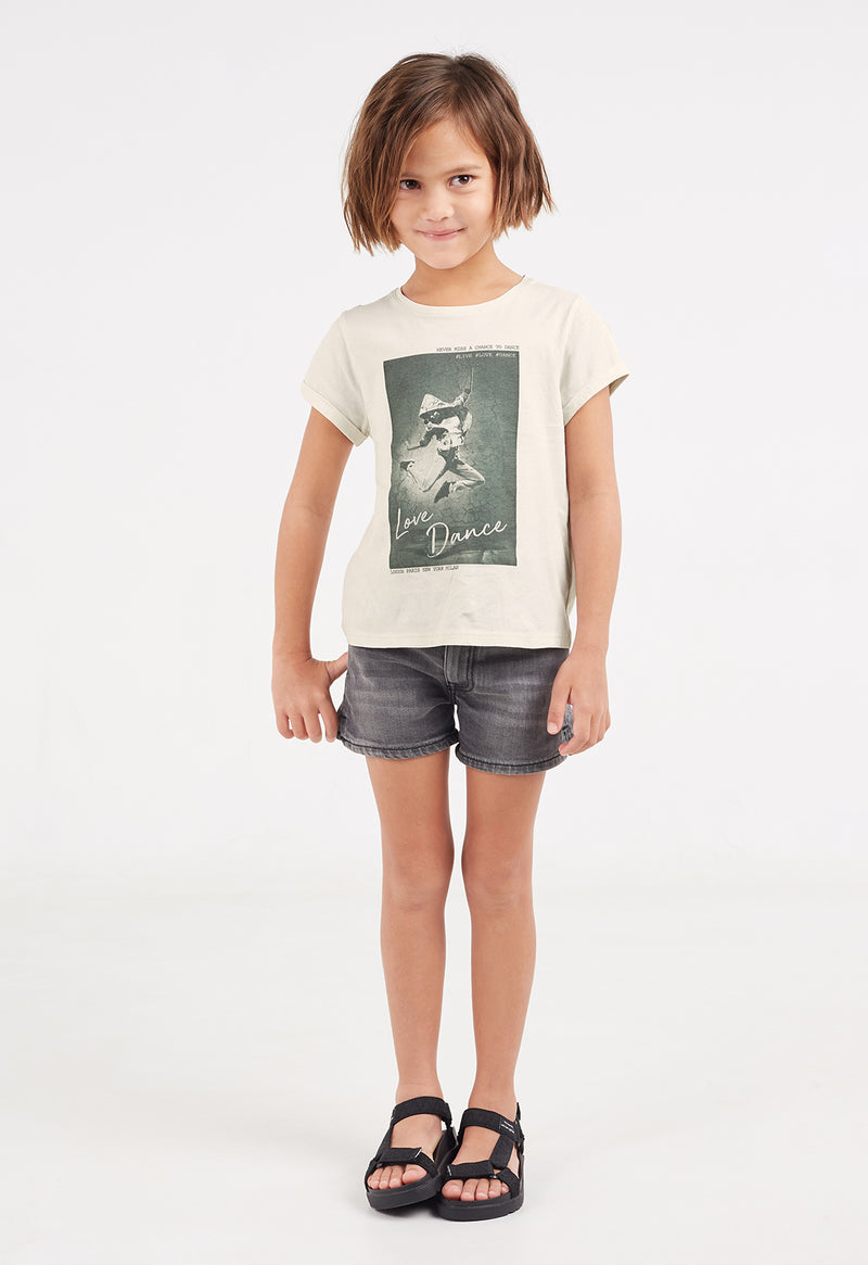 The young girl wears the “Love Dance” Girls Digital Print T-Shirt by Gen Woo