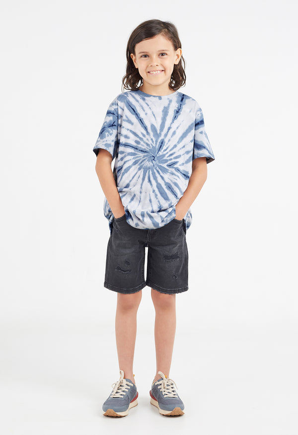 The young boy wears the Boys Navy Blue Tie-Dye T-Shirt by Gen Woo with denim shorts and sneakers