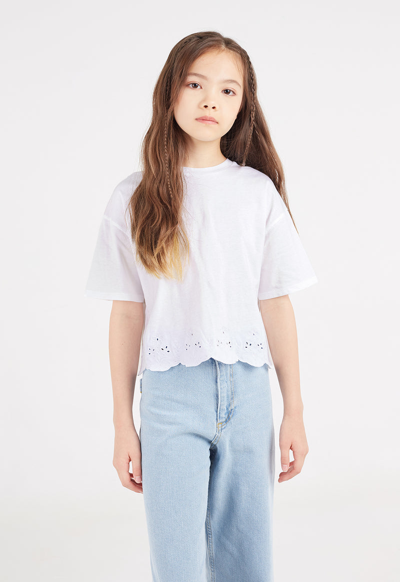 The teen girl wears the White Broderie Trim Girls T-Shirt by Gen Woo