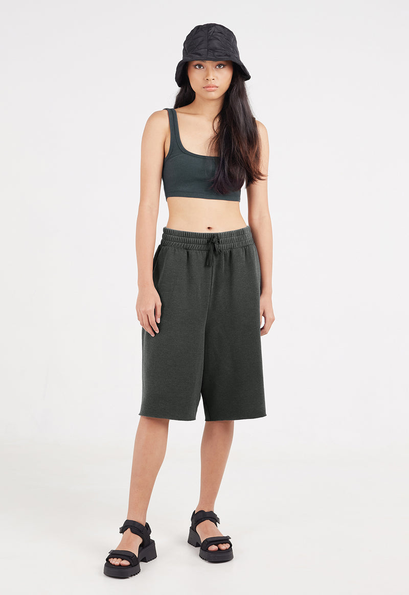 The model wears the Ladies Elasticated Bermuda Lounge Shorts by Gen Woo with a bucket hat and chunky sandals