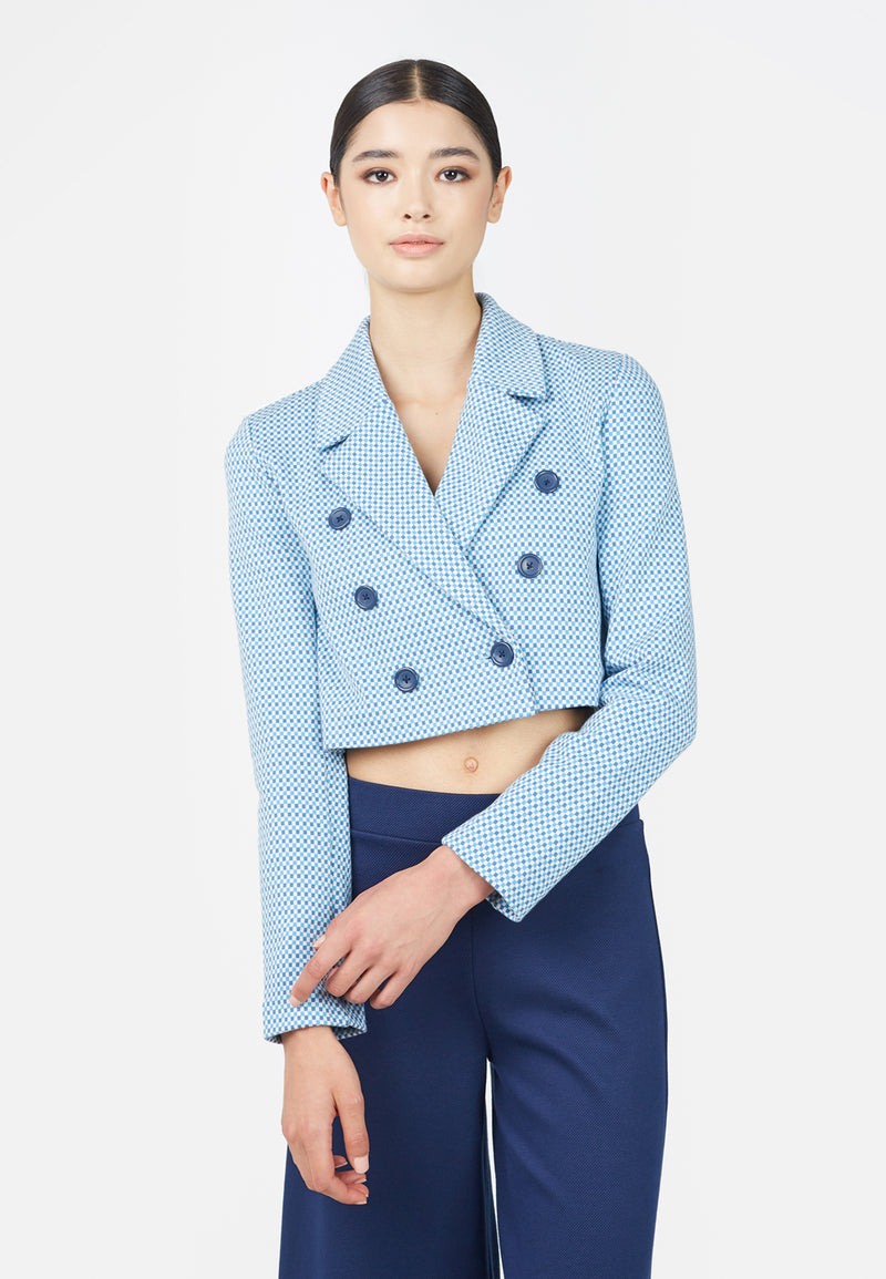 Model wears Jacquard Cropped Ladies Blazer in blue by Gen Woo with dark blue trousers