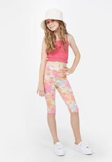 The teen girl wears the Retro Floral Cropped Leggings by Gen Woo with a bucket hat and cami top