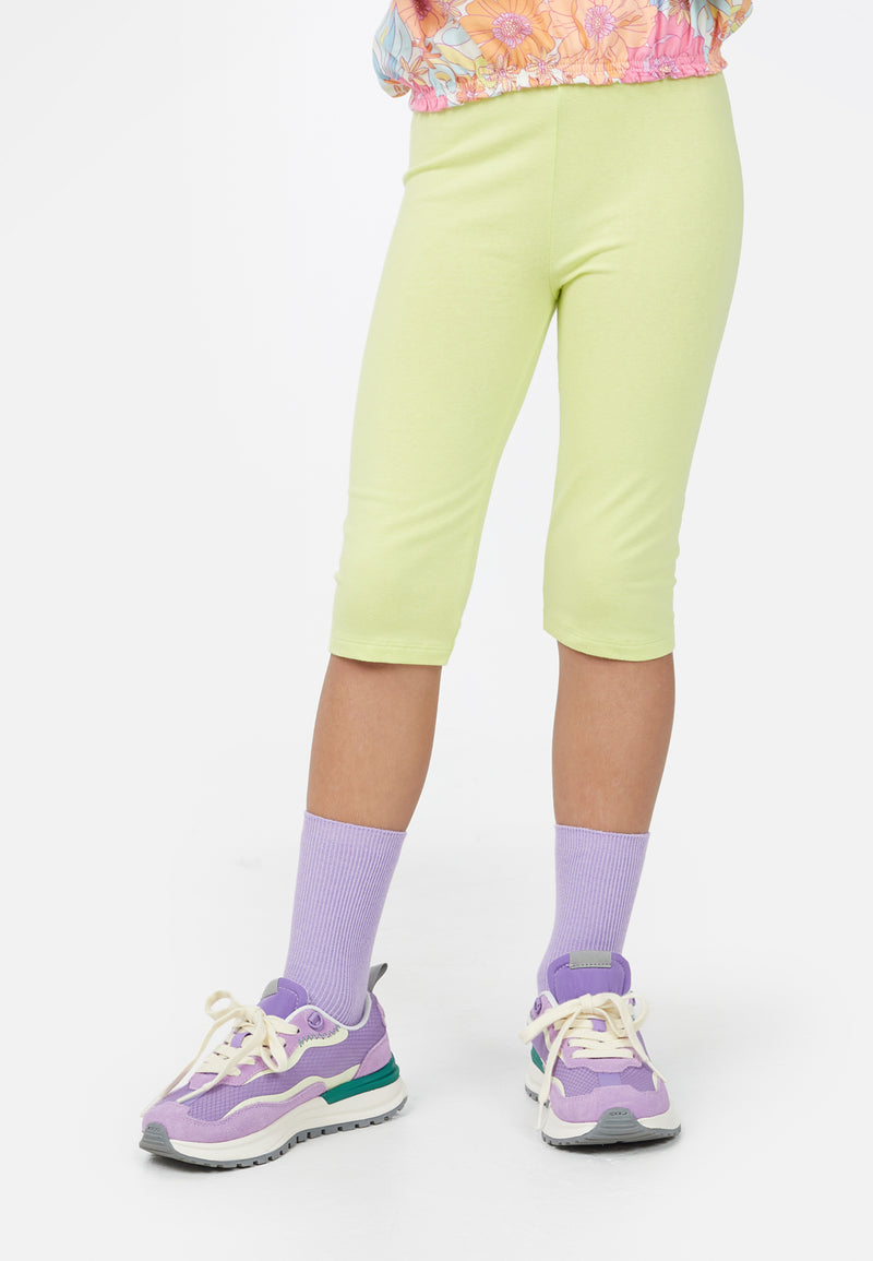 Close up as the young girl wears the Neon Lime Cropped Girls Leggings by Gen Woo