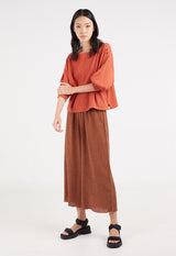 Model wears maxi skirt and Ladies Russet Waffle Detail Top by Gen Woo.