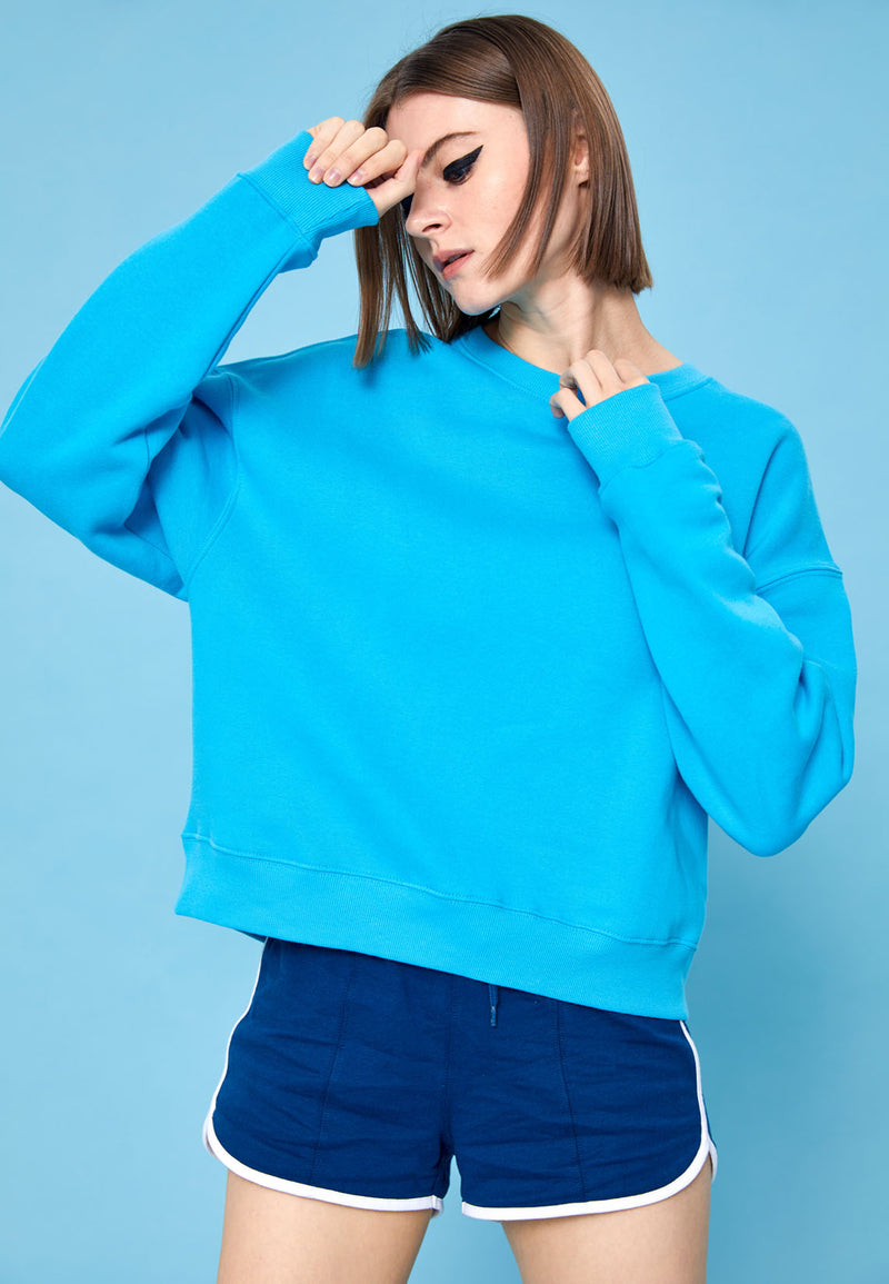 The model wears the Blue Relaxed Fit Crew Neck Ladies Sweater by Gen Woo