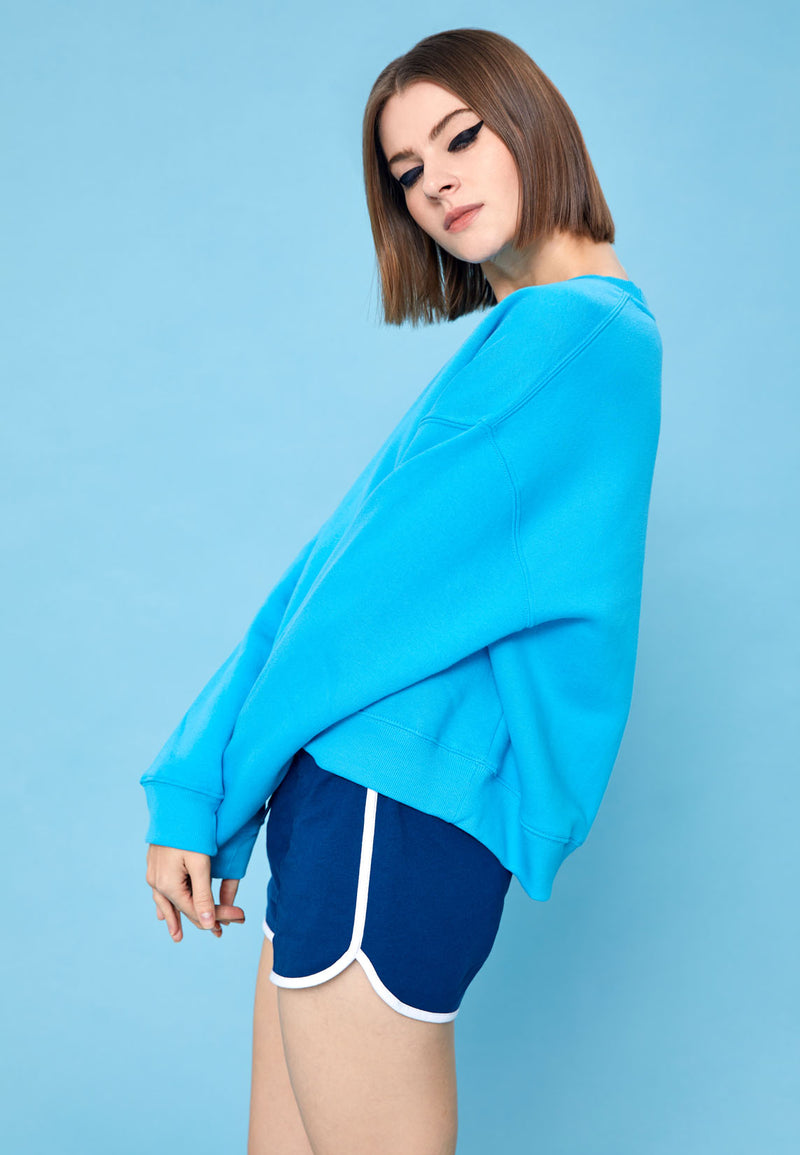 The model poses in the Blue Relaxed Fit Crew Neck Ladies Sweater by Gen Woo