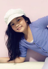 Close-up as the young girl wears the Purple Pointelle Henley Girls Cropped Top by Gen Woo